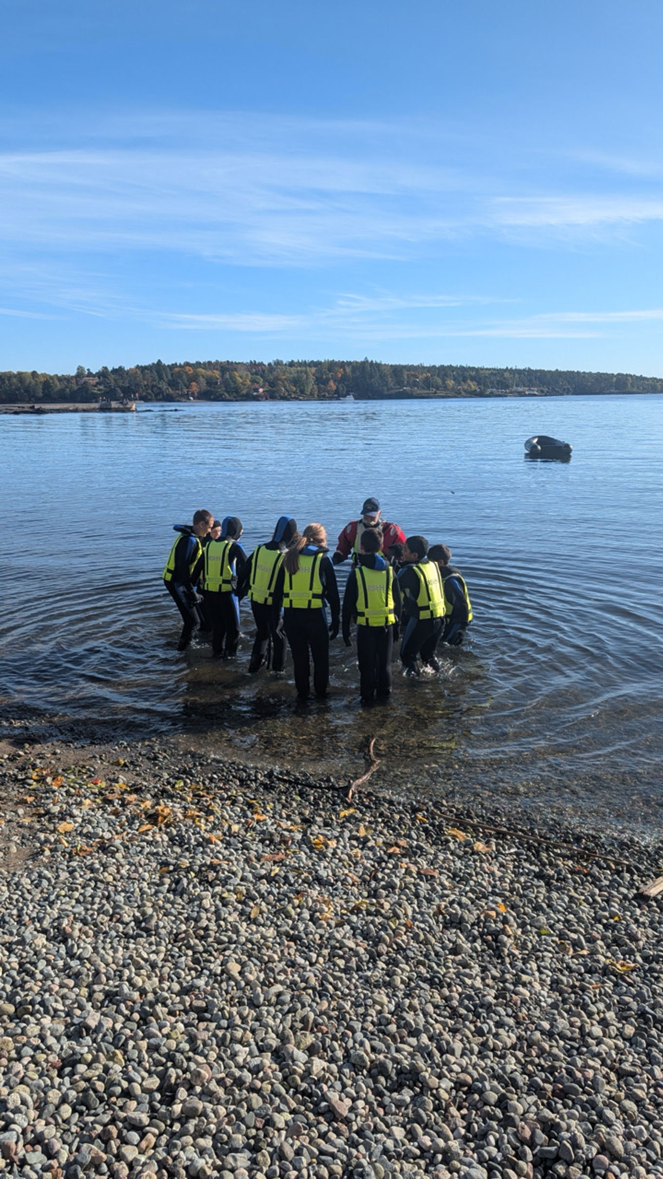 en gruppe mennesker som står på en steinete strand