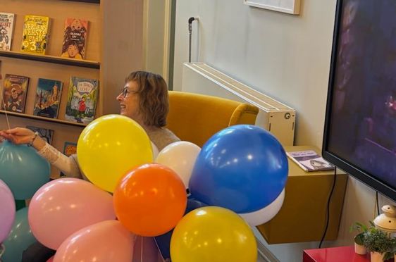 en person som holder en haug med ballonger