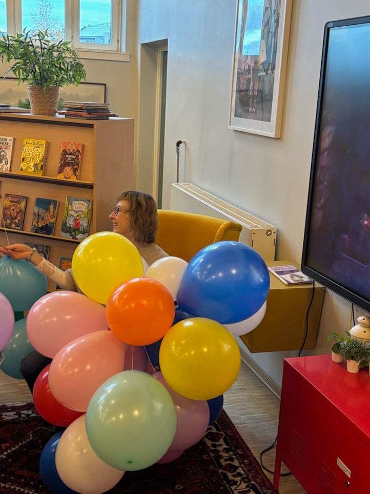 en person som holder en haug med ballonger