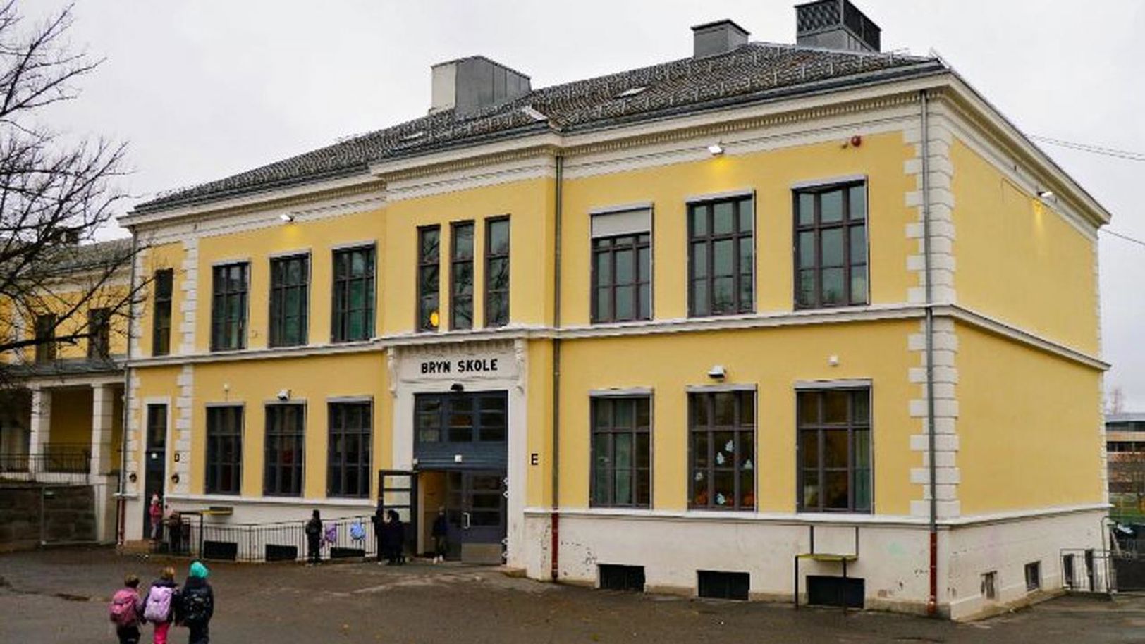 En gul bygning med folk som går rundt